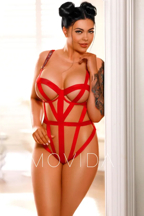 Amelinda standing in a red set of lingerie  Profile Image