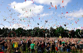 a festival with a crowd of people and streamers in the air