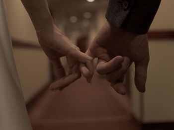 an escort and her client holding hands