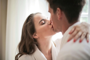 an escort and her client kissing in bathrobes