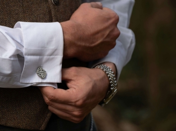 a man wearing a watch adjusting his cufflinks