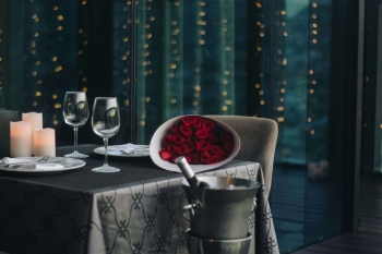 a candlelit dinner with two wine glasses and roses