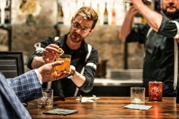a bartender handing a customer a drink