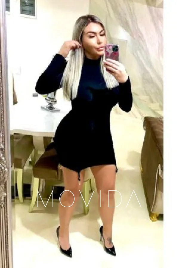 Clara taking a mirror selfie wearing a black dress Profile Image