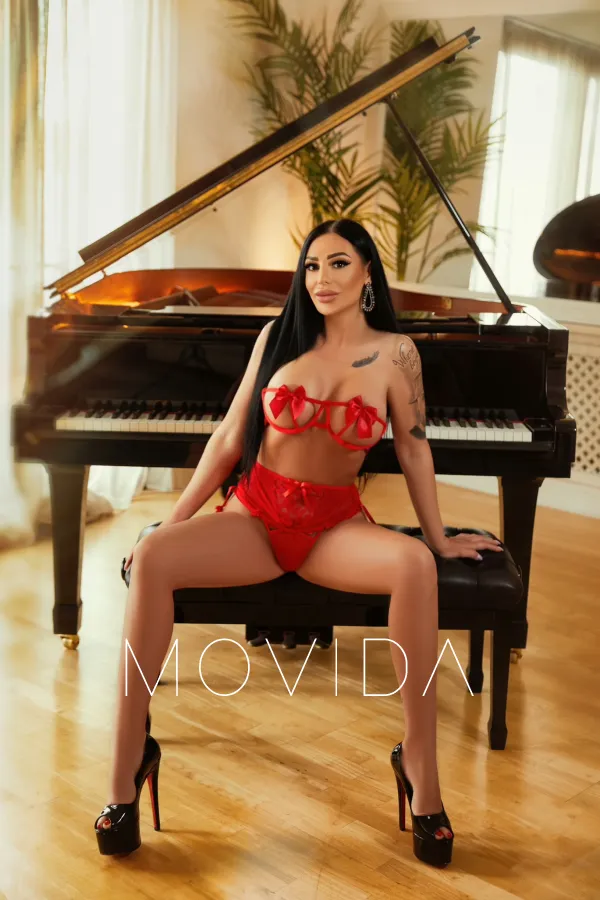 Angelina sitting down by the piano in red lingerie  Profile Image