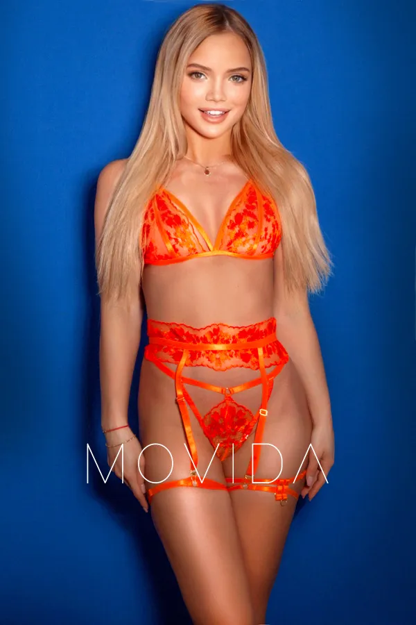 Lidia standing in a set of bright orange lingerie  Profile Image